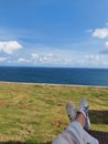 sea Ã¢â¬â¹Ã¢â¬â¹blue, beautiful clouds, the wind blows with my casual sneakers Royalty Free Stock Photo